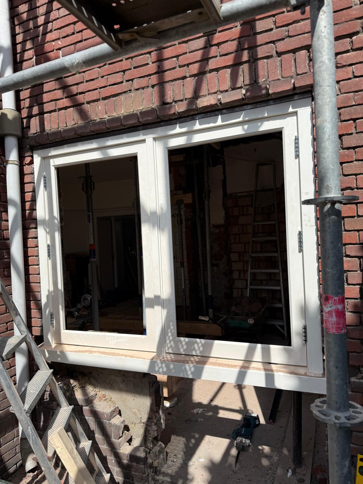 Houten raamkozijn geplaatst in een gemetselde opening