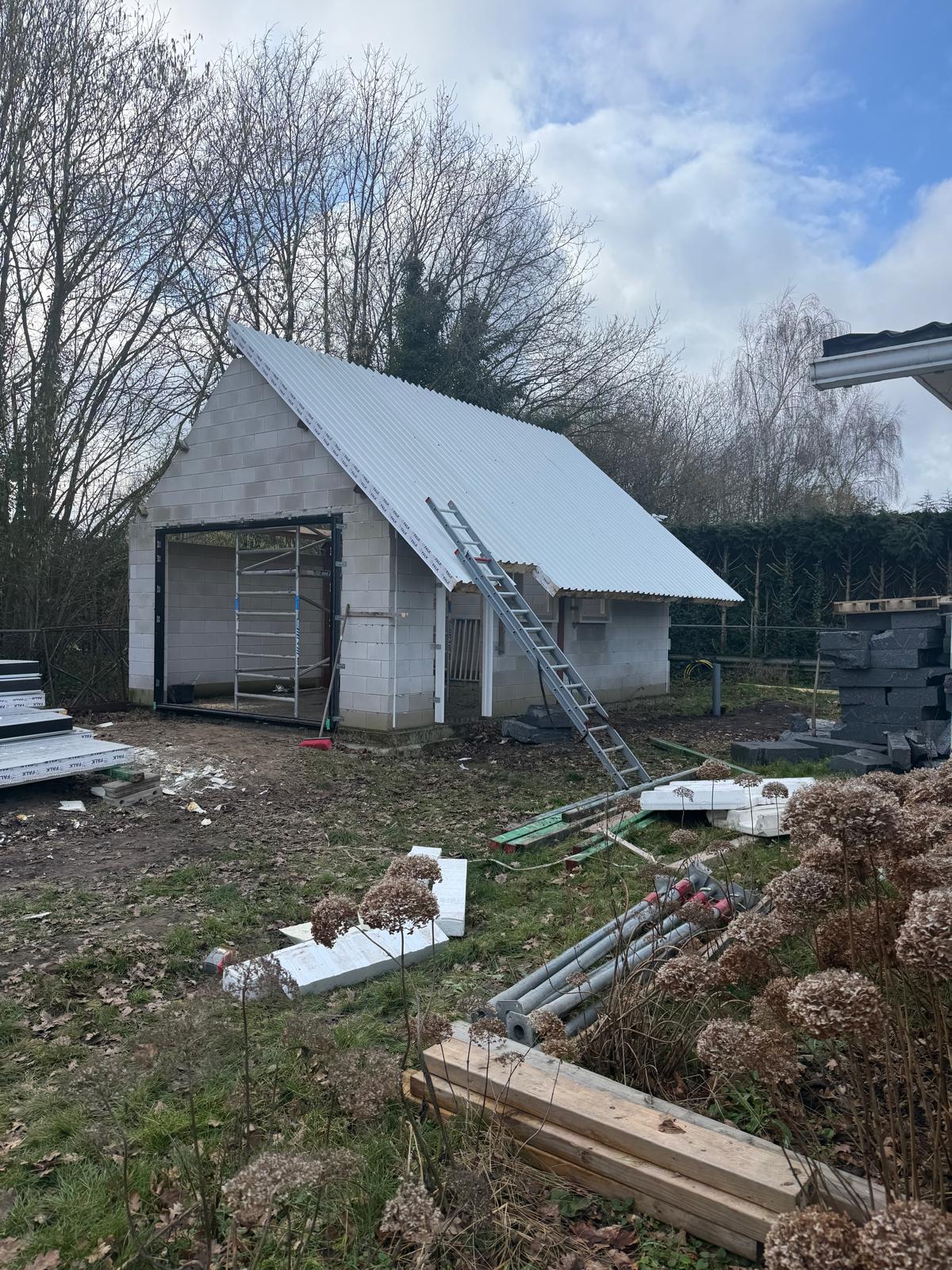 Bijgebouw met nieuwe dakplaten en isolatie tijdens de renovatie