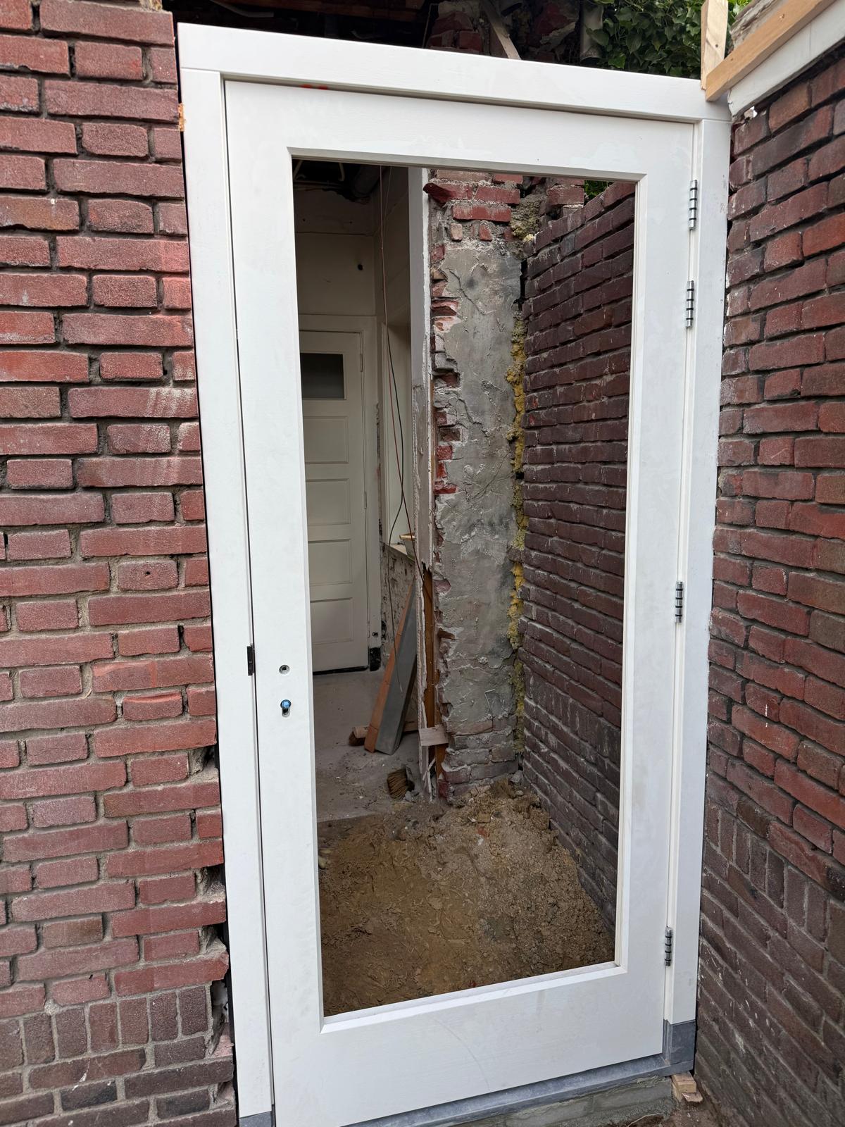 Houten deurkozijn geplaatst in een bakstenen opening